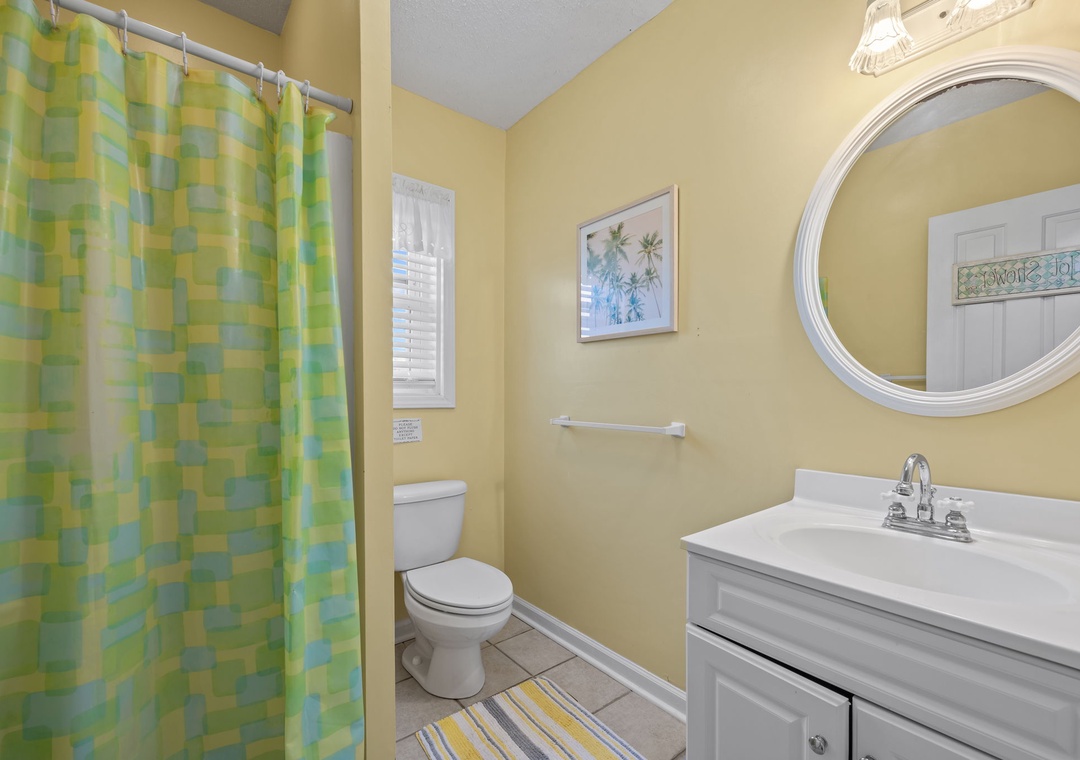 Your bright, cheerful bathroom features a refreshing shower, modern vanity, and coastal-inspired décor that sets a relaxing vacation mood.