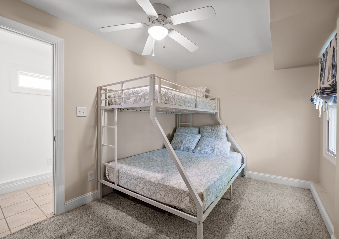 Your comfortable bunk bed setup offers extra sleeping space with soft linens and a ceiling fan to keep you cool.