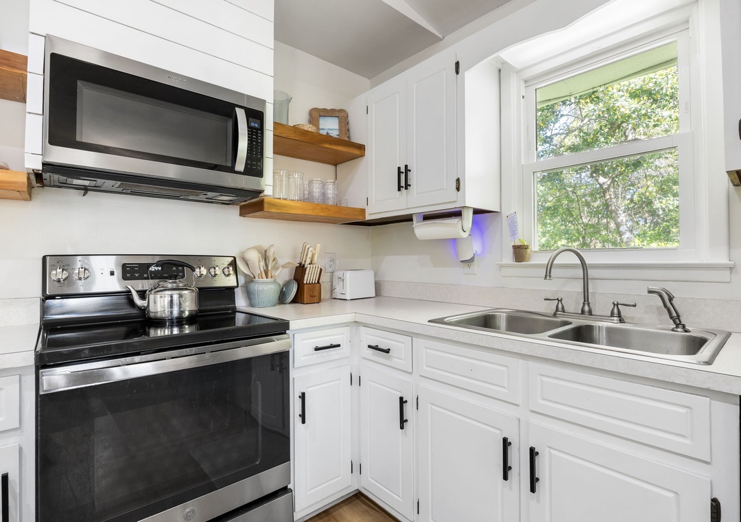 Cook your favorite meals in this bright, fully-equipped kitchen with modern appliances and charming garden views from the window.