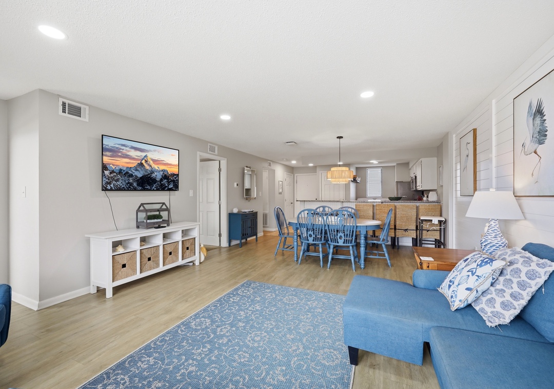 Settle into this spacious, light-filled living area where you'll find comfort and style. Relax on the cozy sofa, gather at the dining table, and enjoy modern amenities in your bright, inviting home away from home.