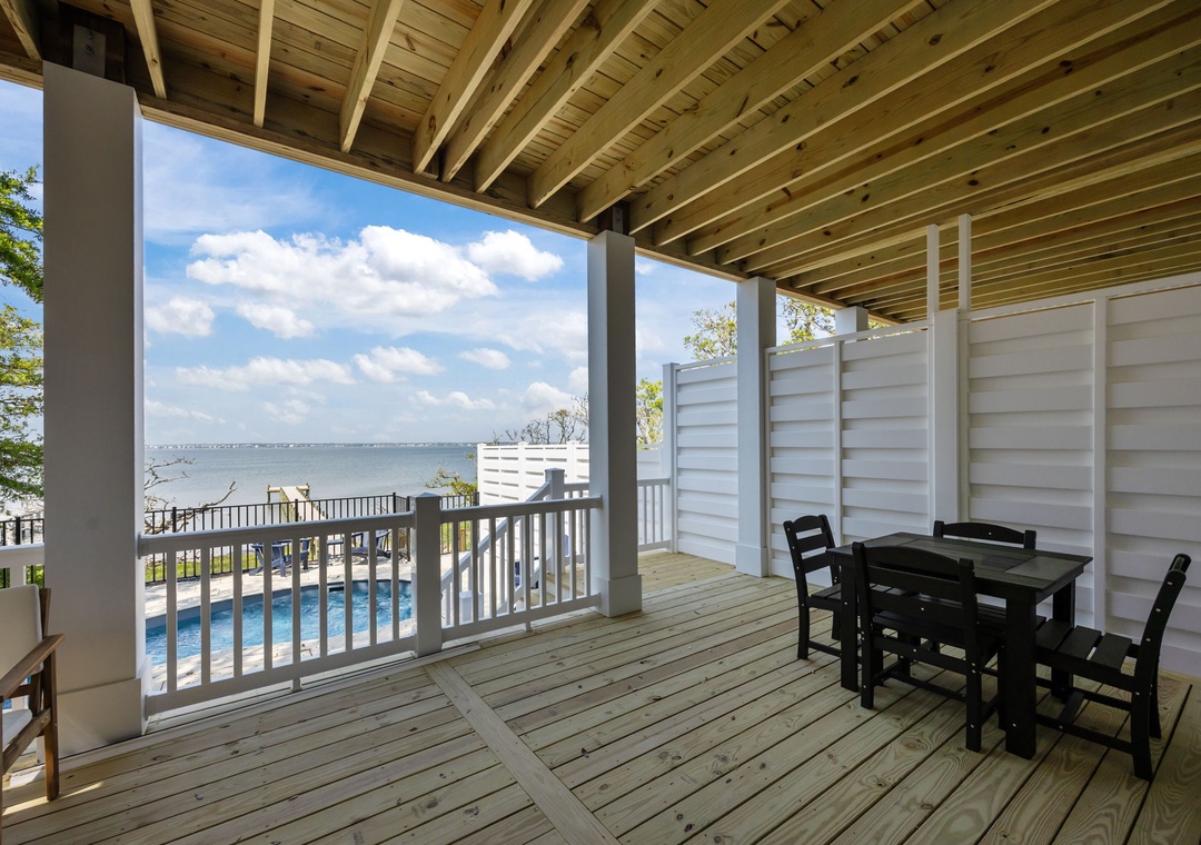Your covered terrace offers stunning water views and poolside dining - perfect for morning coffee or sunset meals overlooking the serene waterfront.