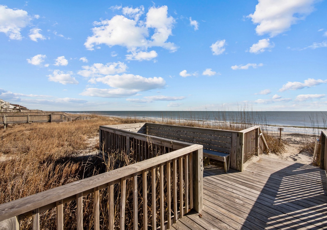 Elevated coastal boardwalk with scenic overlook leads directly to pristine shoreline and expansive ocean views.