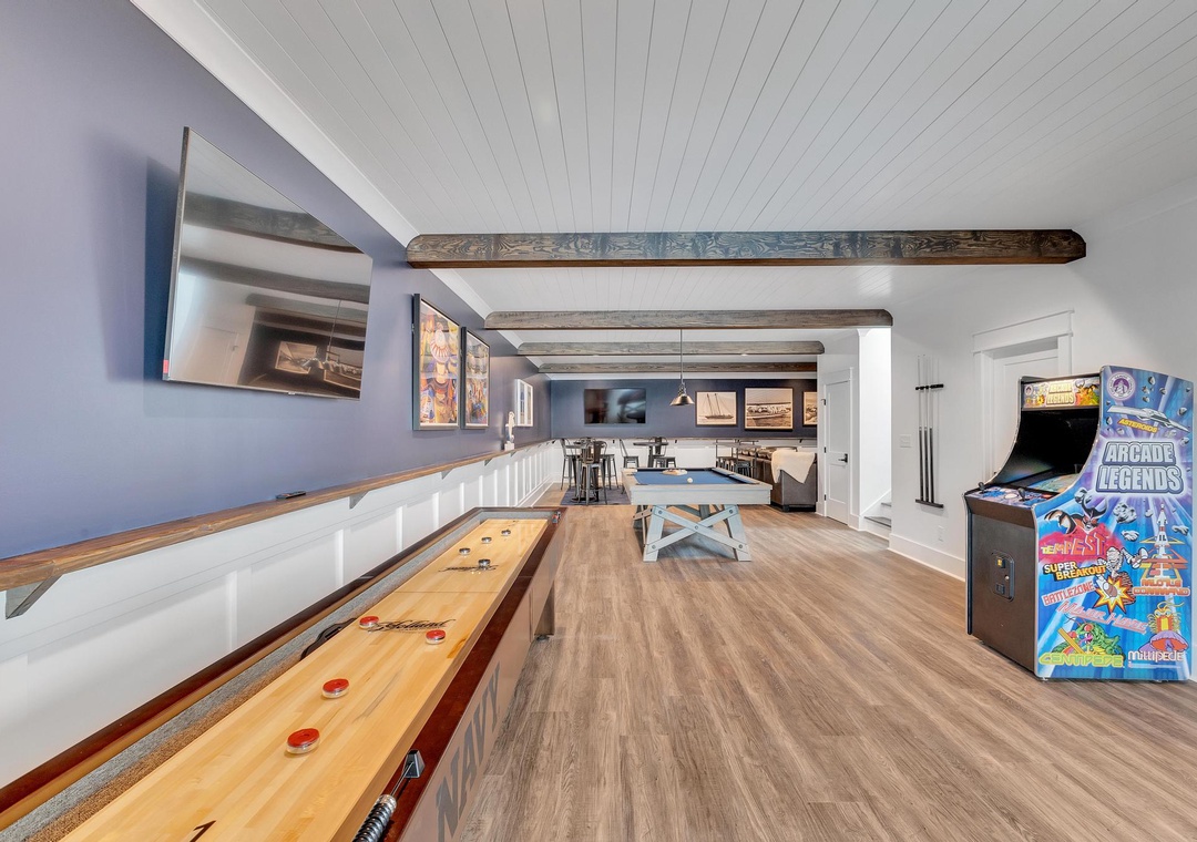 Your perfect retreat awaits, featuring a game room with shuffleboard, arcade, and cozy seating—complete with rustic beams and endless entertainment for your group.