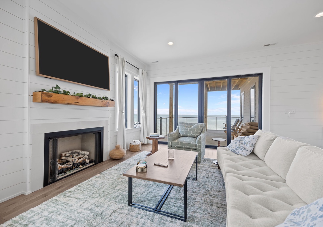 Cozy up by your fireplace while enjoying stunning views through floor-to-ceiling windows that flood this stylish living space with natural light.