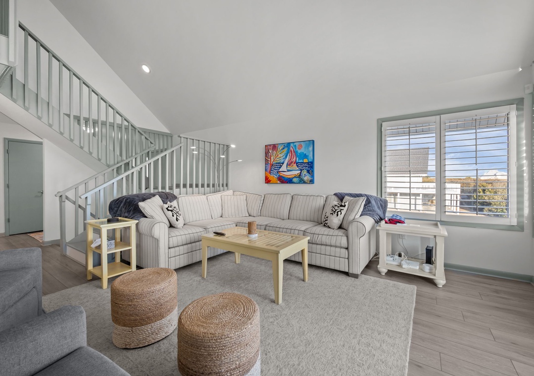 Unwind in your spacious living room with comfortable sectional seating and vibrant coastal artwork that sets the perfect vacation mood.
