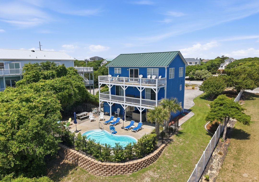 Charming coastal beach house with private pool and spacious multi-level deck, nestled among lush greenery in a quiet residential neighborhood, just moments from the shore.