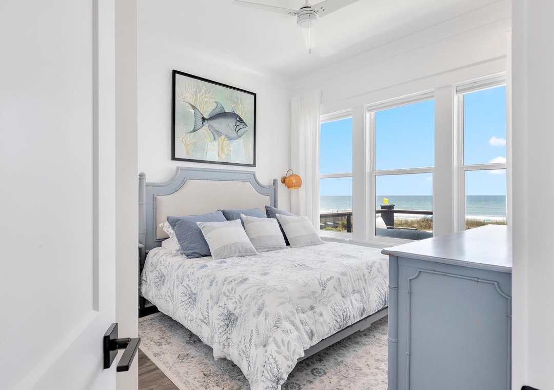 Wake up to stunning sea views framed by floor-to-ceiling windows, where the ocean and sandy beach become your morning vista in this serene coastal bedroom.
