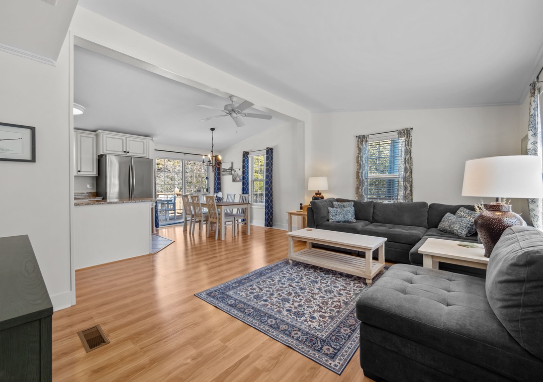 Relax in your spacious open-plan living area, where gleaming hardwood floors and comfortable sectional seating create the perfect spot for unwinding together.