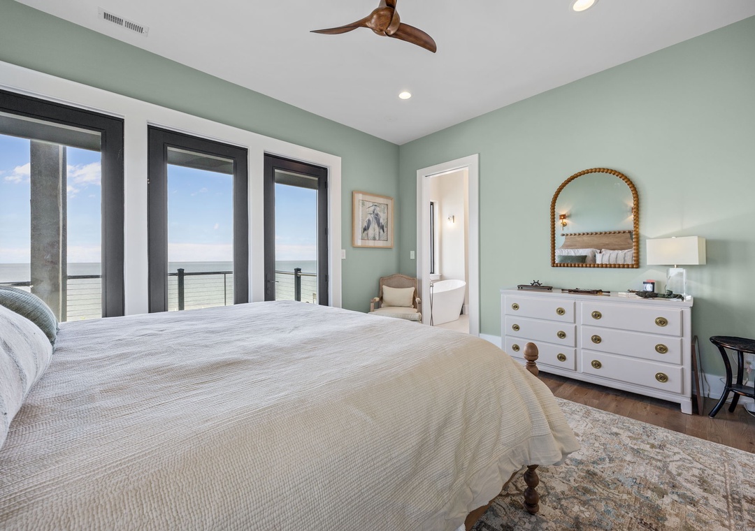Wake up in your serene coastal bedroom where soothing green walls and plush bedding create the perfect retreat after days exploring the shore.