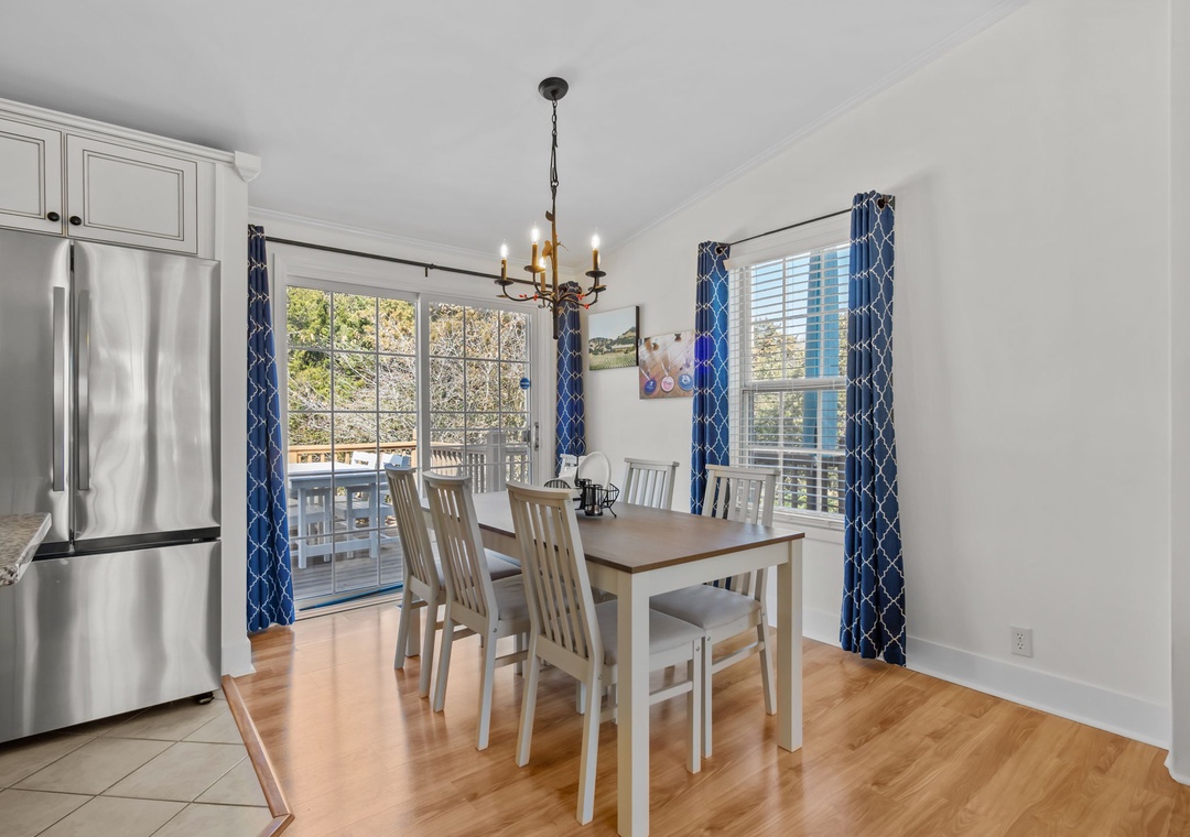 Gather around your bright dining table for memorable meals, with sunlight streaming through elegant blue curtains and city views beyond.