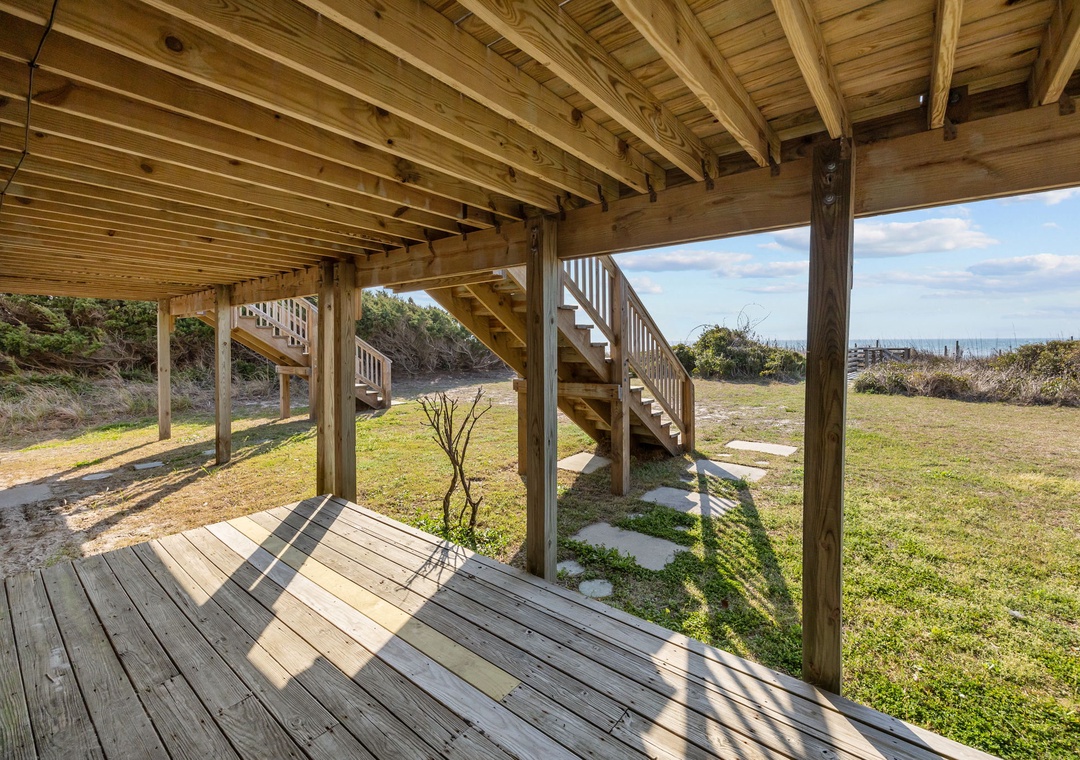 Step onto your private deck and feel the coastal breeze as sunlight filters through natural wood beams above.