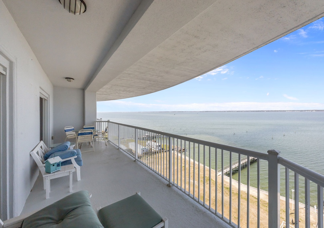 Spacious waterfront balcony with comfortable seating where you can enjoy morning coffee while watching the waves.
