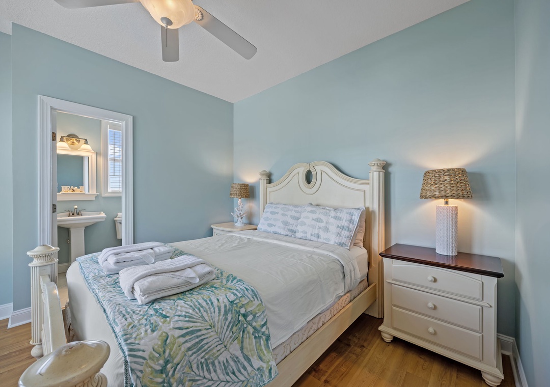 Drift off in your tranquil coastal bedroom, where soft blue walls and tropical touches create the perfect seaside sanctuary.