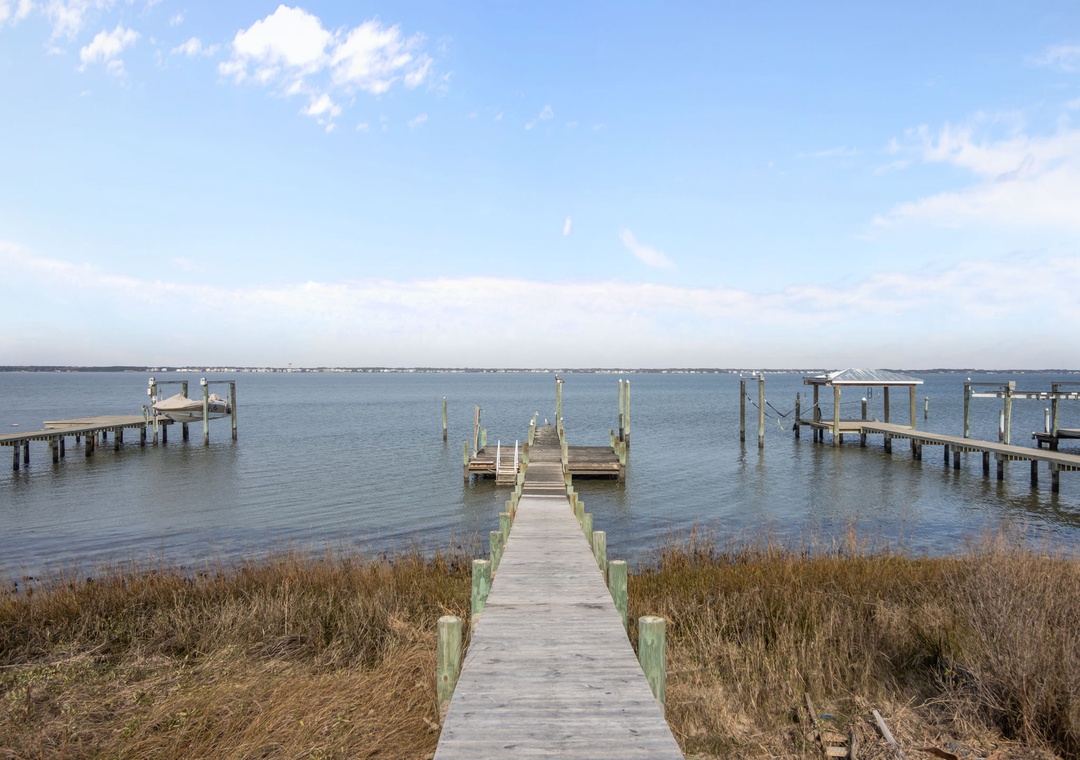 Waterfront location with private dock access to calm bay waters, surrounded by peaceful natural marshland.