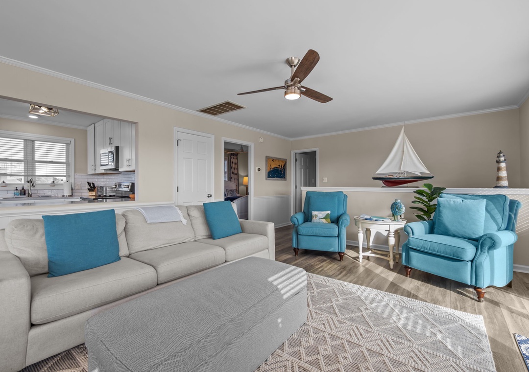 Relax in your coastal-themed living room with plush seating, nautical touches, and an open layout connecting to your kitchen.