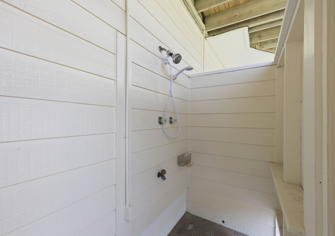 Step into your private outdoor shower, where rustic wood beams and fresh white shiplap create a refreshing escape after a day at the beach.