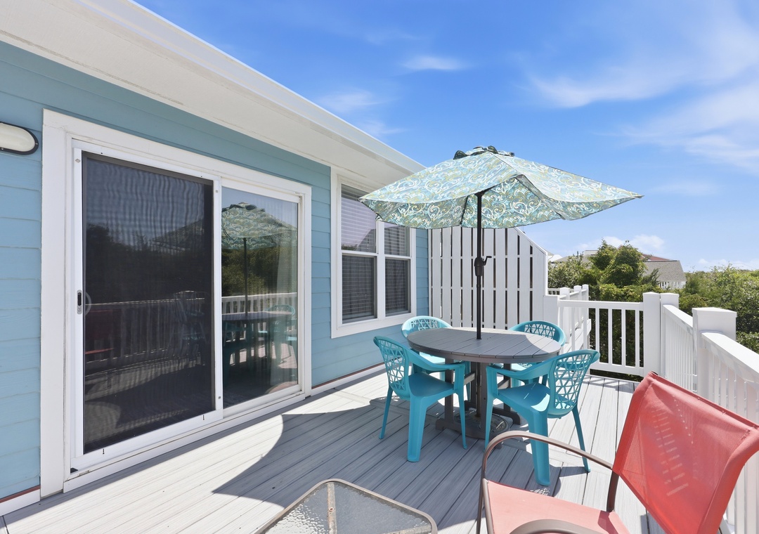 Your private deck offers a perfect spot to enjoy morning coffee or afternoon refreshments outdoors, complete with shaded dining for four and comfortable seating under coastal skies.