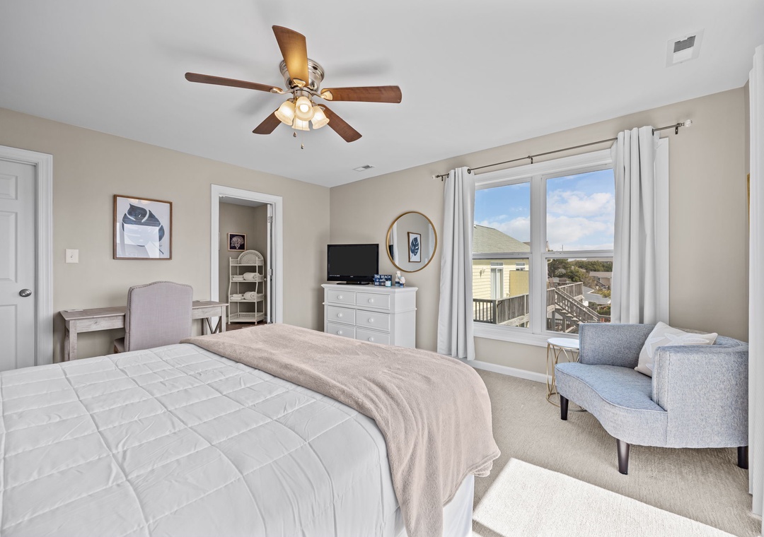 Relax in your serene bedroom with ocean views and coastal charm, featuring plush bedding and a cozy reading nook.