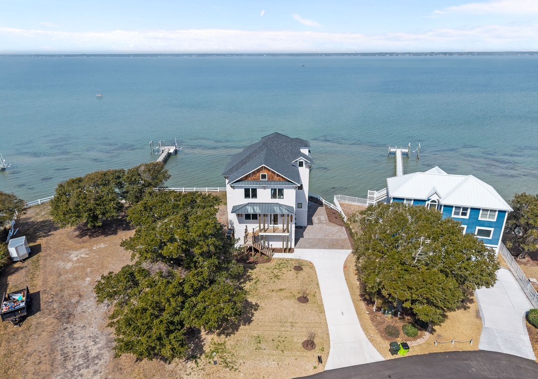 Waterfront property with private beach access and docks, surrounded by mature trees on the bay.
