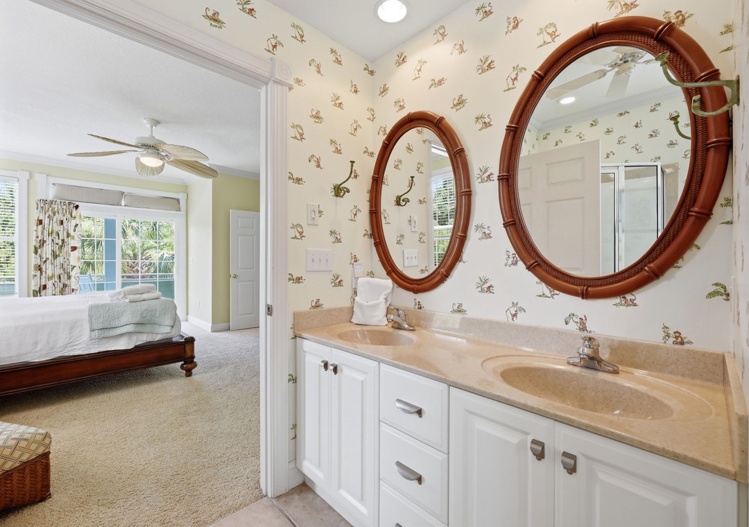 Refresh in your charming en-suite bathroom featuring double sinks and unique tropical mirrors before retiring to your airy bedroom with garden views.