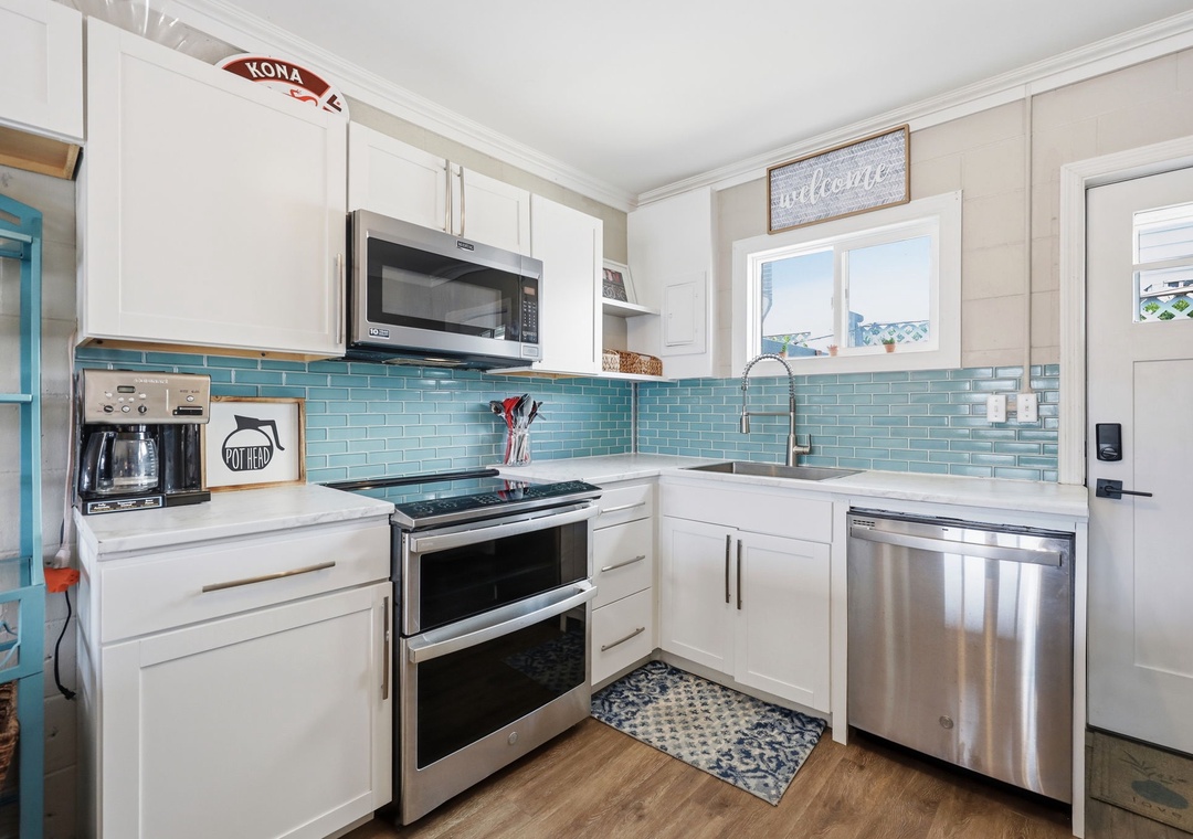Your bright, fully-equipped kitchen features modern appliances, gleaming countertops, and a cheerful turquoise backsplash to inspire your morning coffee routine.