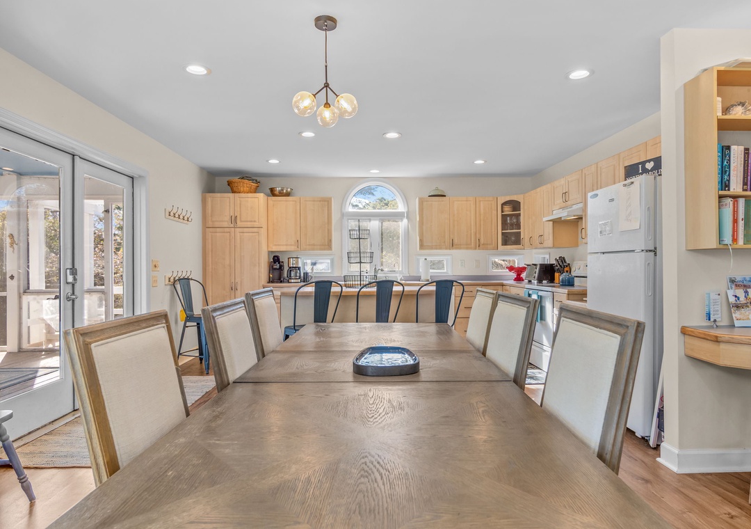 Gather around this spacious dining table where your group can share meals and create memories in this bright, open kitchen.