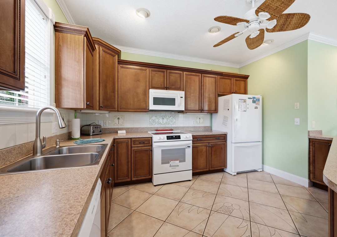 Your fully equipped kitchen features warm wood cabinetry, modern appliances, and ample counter space—perfect for whipping up meals between beach adventures.