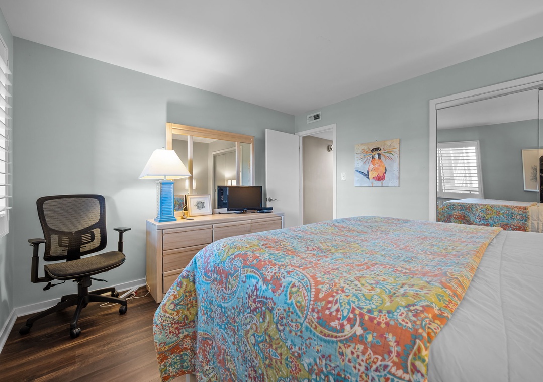 Your peaceful bedroom sanctuary features colorful bedding, natural light, and a dedicated workspace for ultimate comfort.