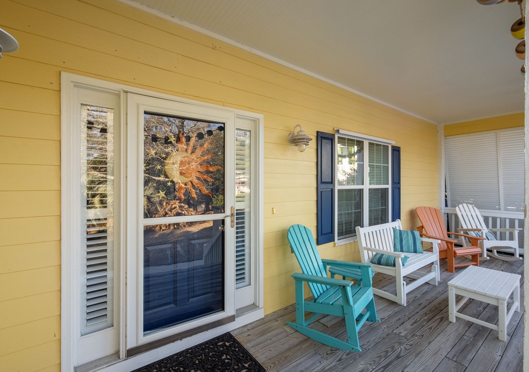Your bright yellow porch welcomes you with colorful Adirondack chairs perfect for morning coffee and sunset conversations.