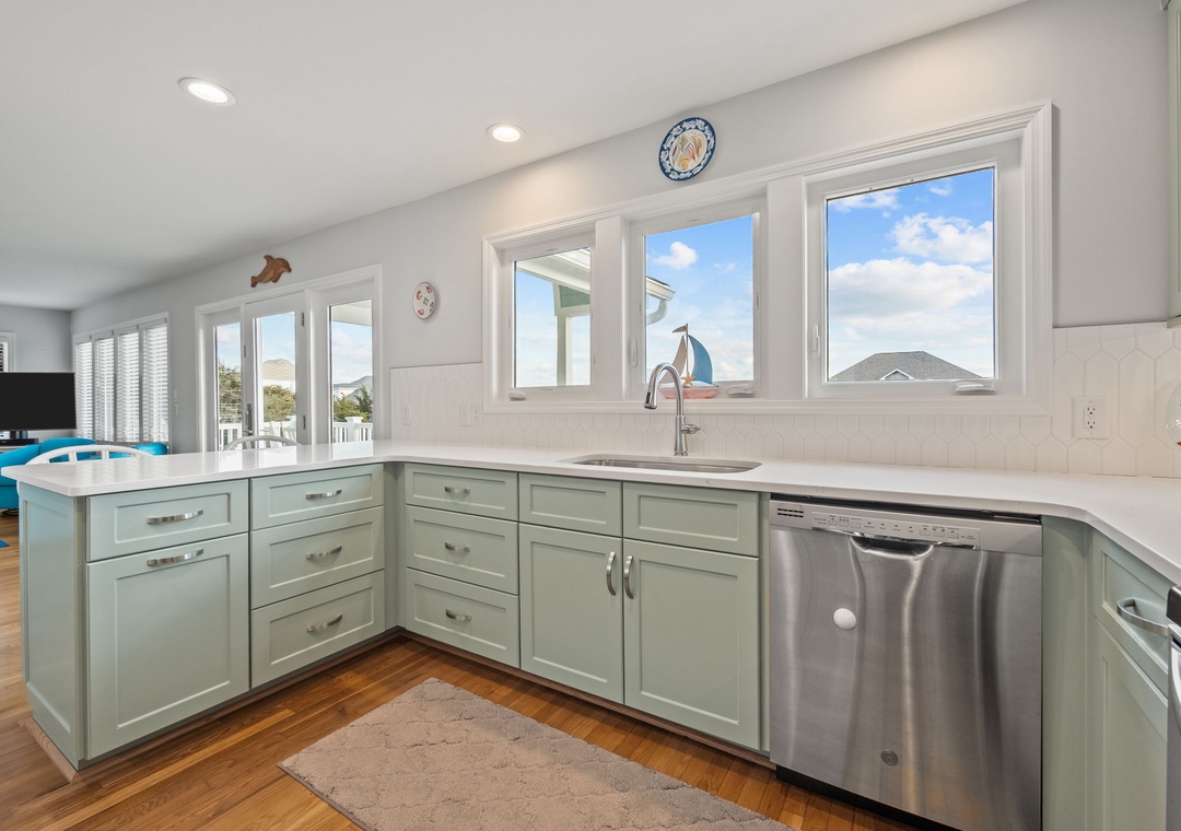 Your bright kitchen features sea-glass cabinets, quartz counters, and panoramic windows flooding the space with natural light.