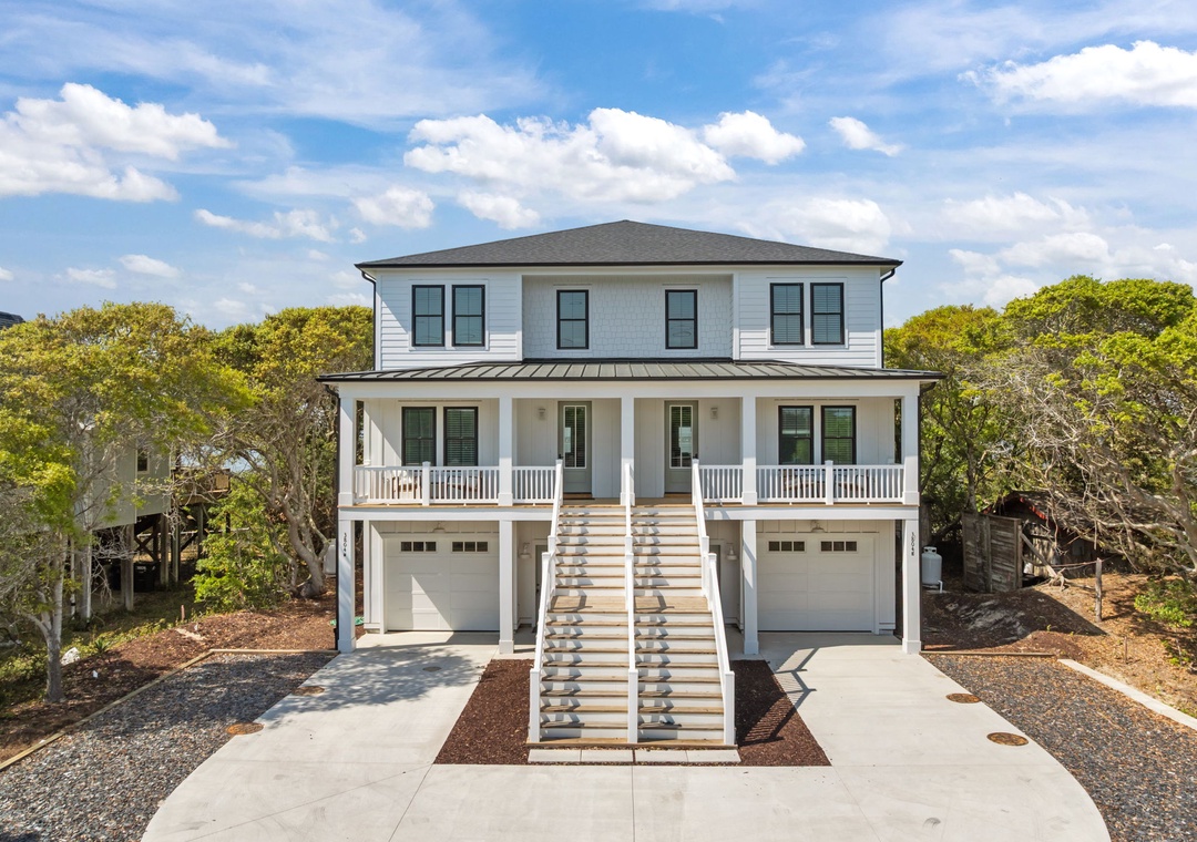 Beautiful coastal home surrounded by lush greenery offers modern comfort with classic charm and convenient parking for your beach getaway.