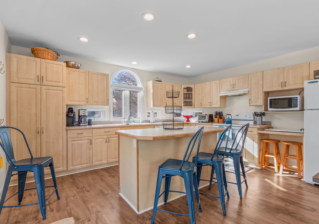 Your spacious kitchen invites culinary adventures with warm wood cabinetry, modern appliances, and a welcoming island perfect for morning coffee or evening gatherings.