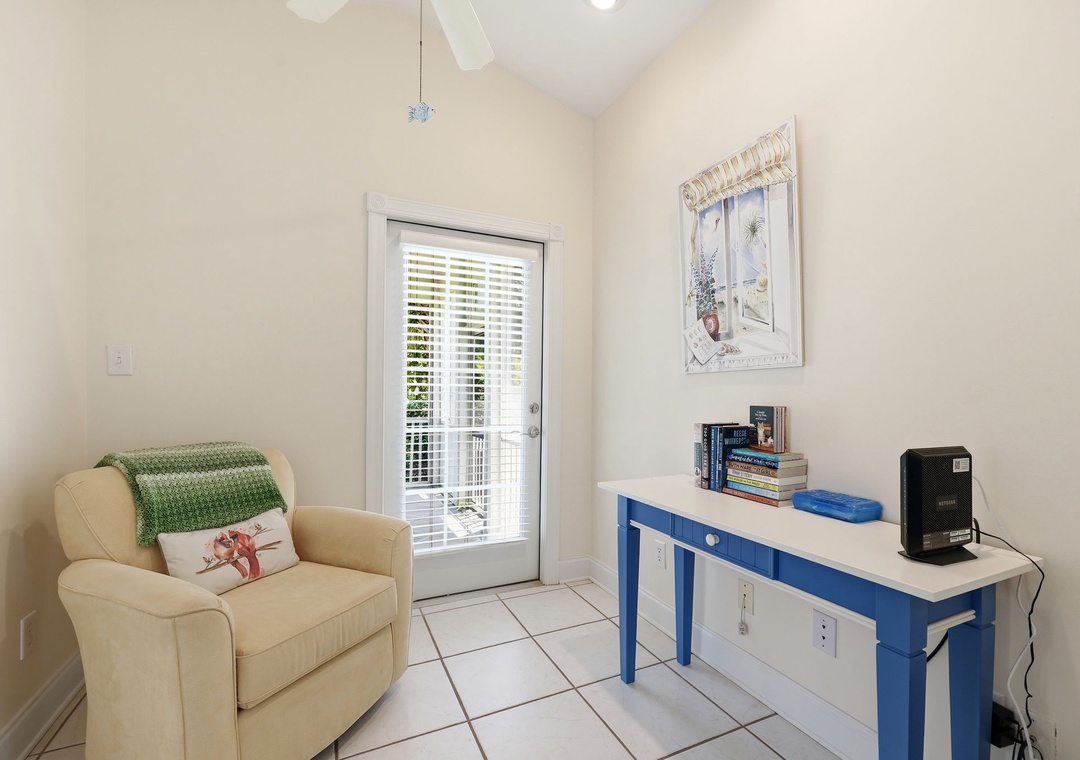 Relax in your cozy reading corner, bathed in natural light from the French door. The soft armchair and charming blue desk create a perfect spot for unwinding with your favorite book.