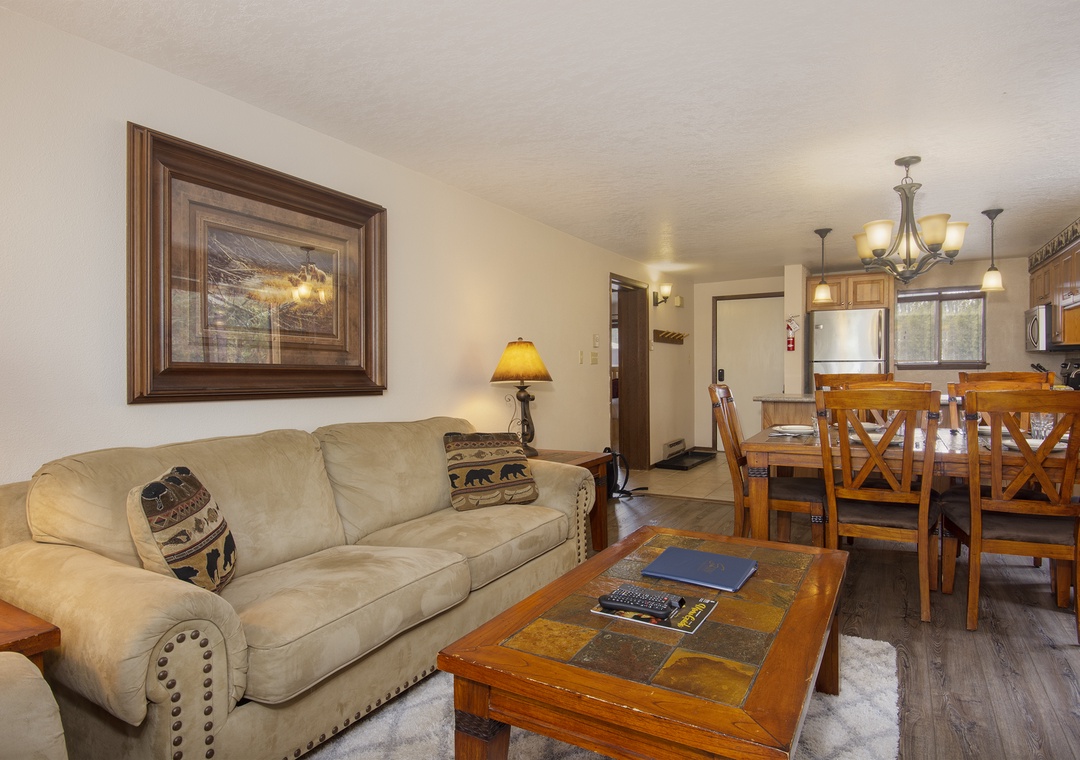 Sink into plush seating where warm mountain artwork and rustic wood create your perfect retreat after adventure-filled days.
