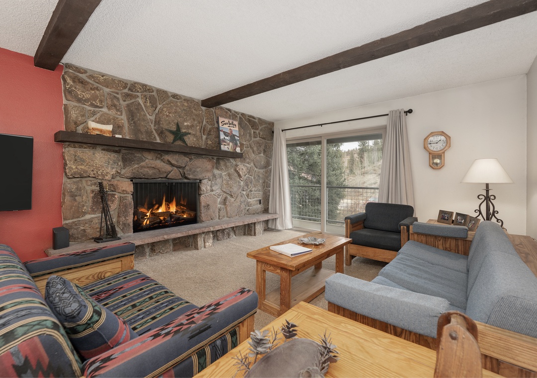 Cozy up by your crackling stone fireplace after mountain adventures, surrounded by comfortable seating and rustic charm.