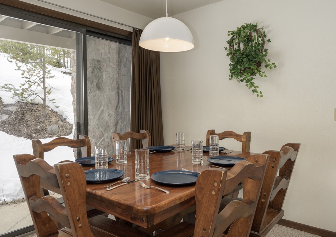 Gather around your dining table for memorable meals while snow-covered scenery creates a peaceful winter backdrop outside your window.