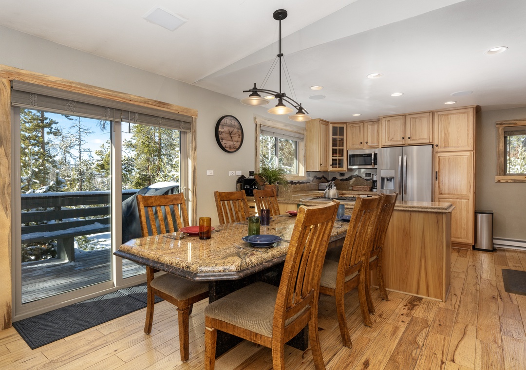 Gather around this elegant granite dining table where warm wood tones and mountain views create the perfect setting for your memorable meals together.