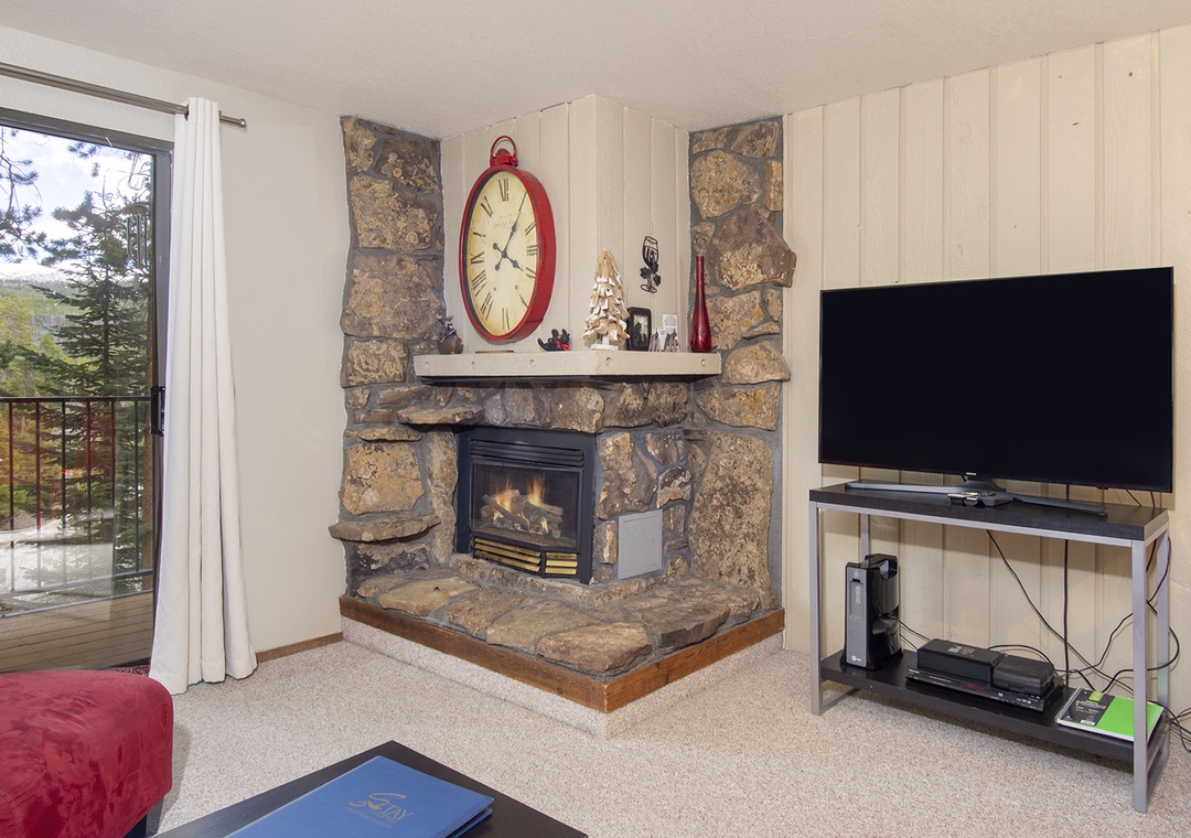 Cozy up by your stone fireplace while enjoying mountain views from the sliding door to your private balcony.