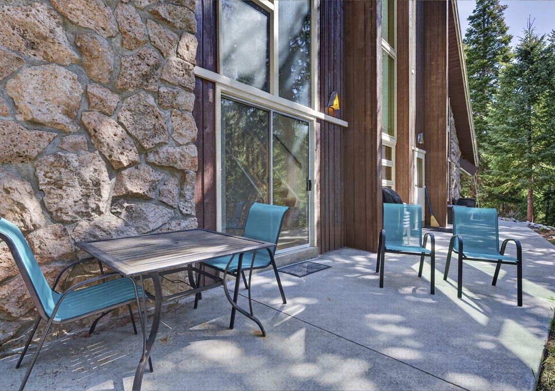 Step out onto your private patio, where mountain air meets rustic stone charm and turquoise seating invites you to linger over morning coffee surrounded by towering pines.