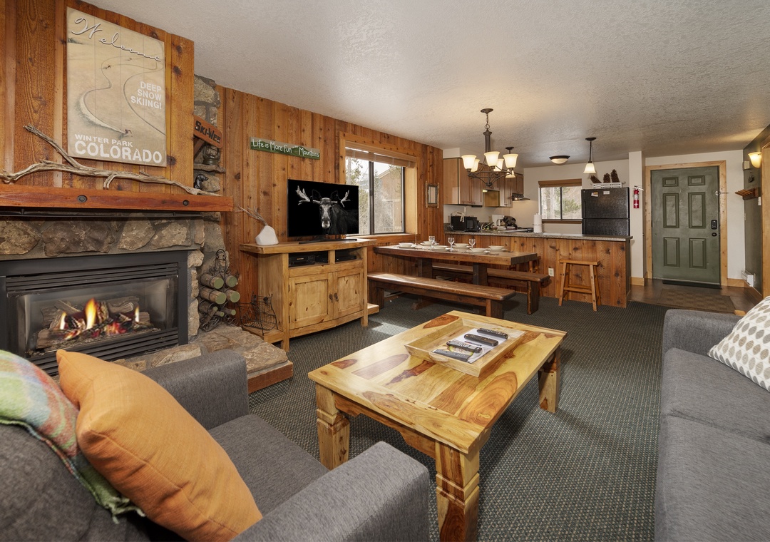 Cozy up by the crackling fireplace while enjoying mountain views from your rustic retreat's open living space.