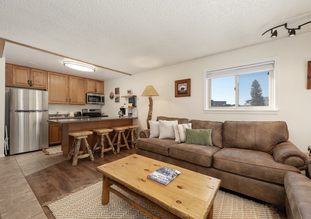 Sink into your comfortable leather sofa and enjoy this cozy open-plan space where rustic charm meets modern comfort in your mountain retreat.