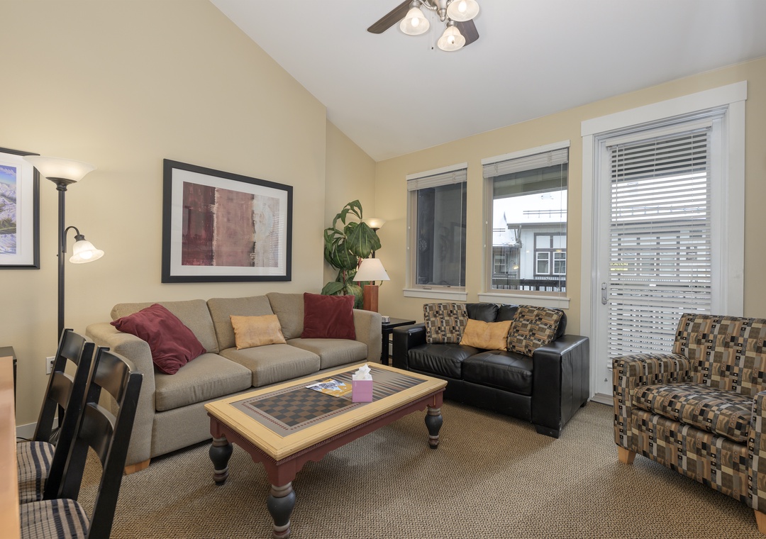 Relax in your comfortable living room featuring plush seating, warm lighting, and large windows that fill the space with natural light.