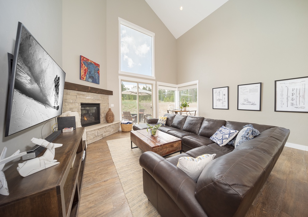 Unwind in your spacious living room with vaulted ceilings, cozy fireplace, and plush leather sectional perfect for movie nights.