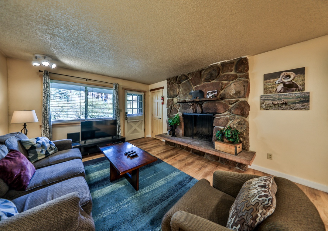 Cozy up by your rustic stone fireplace with plush seating and mountain art creating the perfect après-ski retreat.
