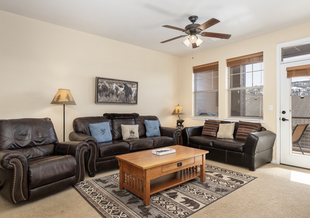 Sink into plush leather sofas in your spacious living room at Ten Mile G-201, where a gentle ceiling fan keeps you cool and natural light streams through large windows.