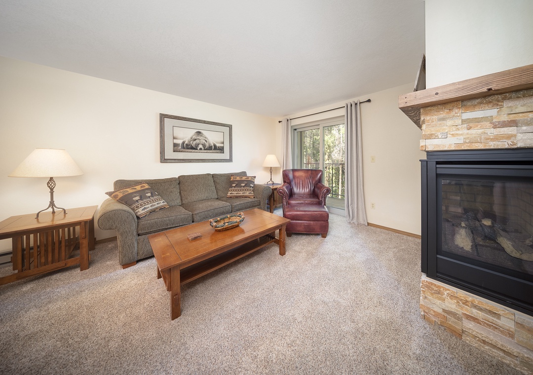 Unwind in your cozy living room with a crackling fireplace, plush seating, and warm mountain lodge charm.