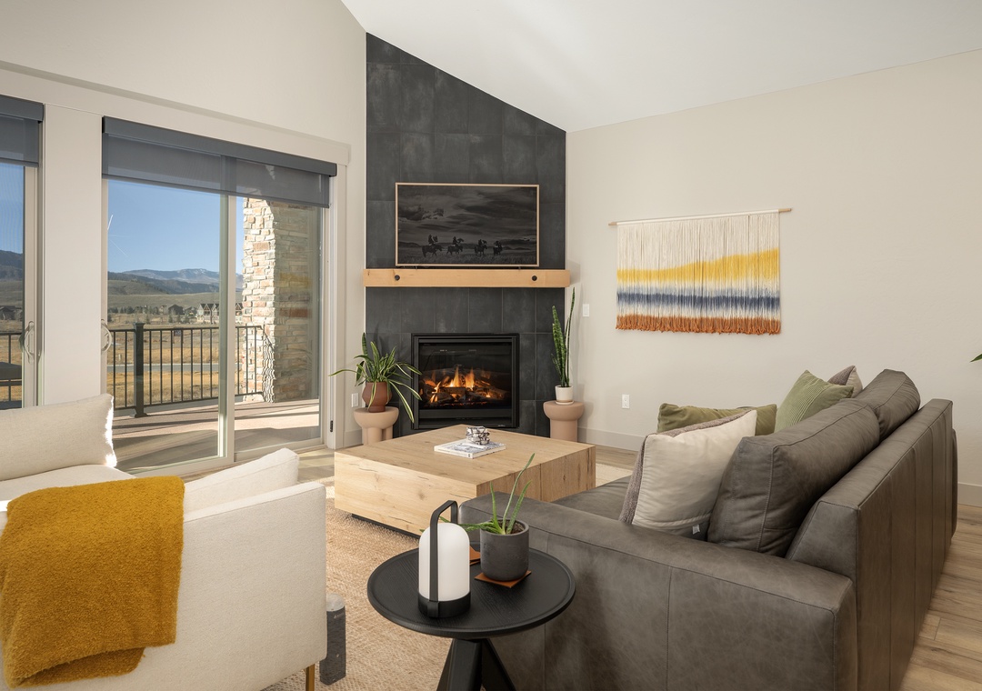 Unwind in your stylish living room with crackling fireplace, mountain views, and plush seating perfect for cozy evenings.