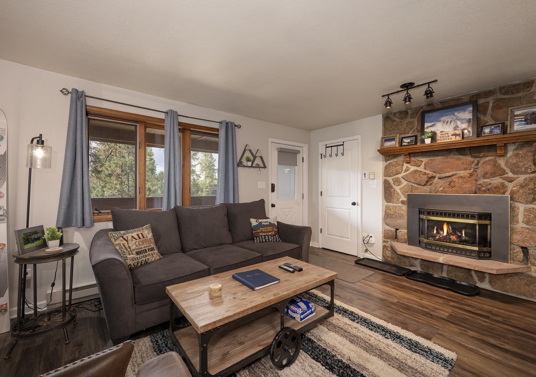 Unwind in your cozy living room with warm fireplace and mountain views through large windows.