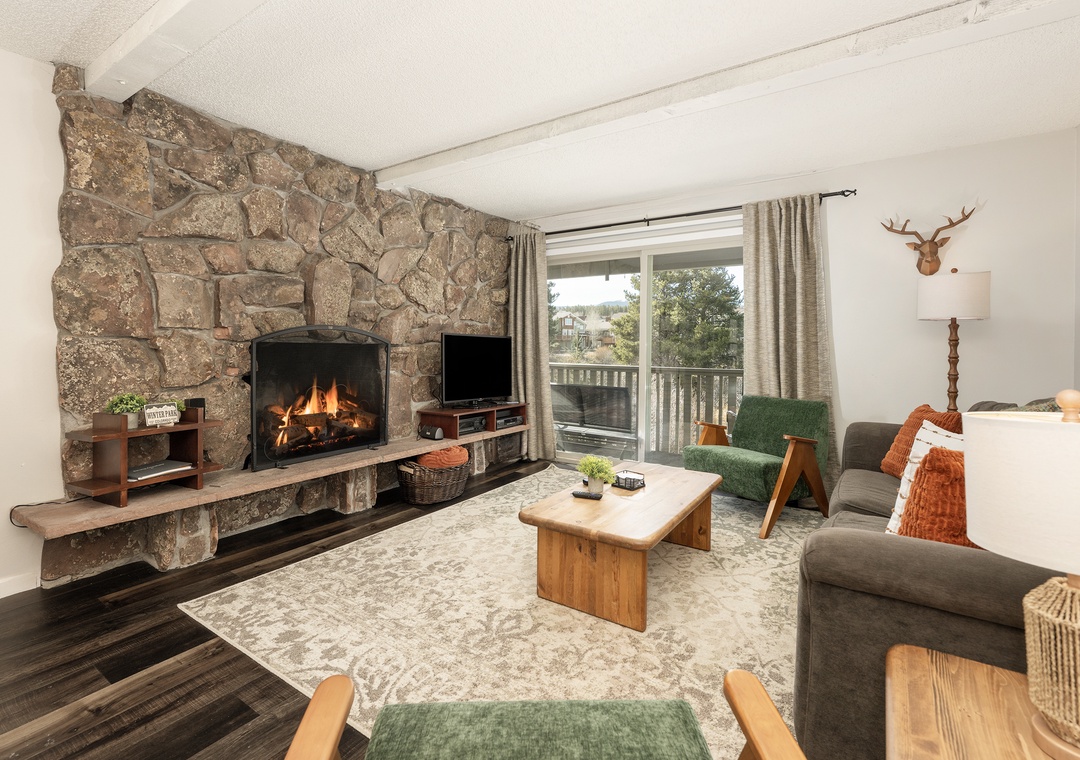 Unwind by your crackling stone fireplace in this cozy living room, where rustic charm meets modern comfort for perfect mountain getaway evenings.