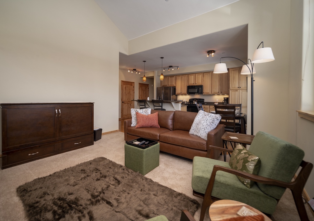Sink into plush leather seating surrounded by warm wood tones and modern lighting in your stylish open-concept living space.